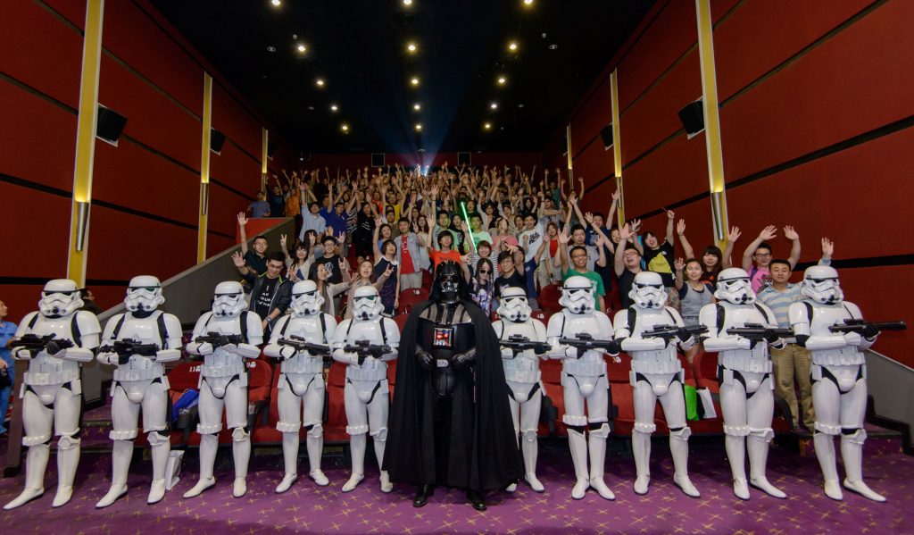 This handout photograph taken on June 14, 2015 and received on June 16, 2015 from Walt Disney Studios China shows Chinese fans (background) posing with Darth Vader (C) and Storm Troopers at a cinema hall in Shanghai. China has become one with the Force by showing the original "Star Wars" film at cinemas for the first time, nearly four decades after it became a global hit and cornerstone of Western popular culture. AFP PHOTO / WALT DISNEY STUDIOS CHINA ----EDITORS NOTE---- RESTRICTED TO EDITORIAL USE - MANDATORY CREDIT "AFP PHOTO / WALT DISNEY STUDIOS CHINA" - NO MARKETING NO ADVERTISING CAMPAIGNS - DISTRIBUTED AS A SERVICE TO CLIENTS